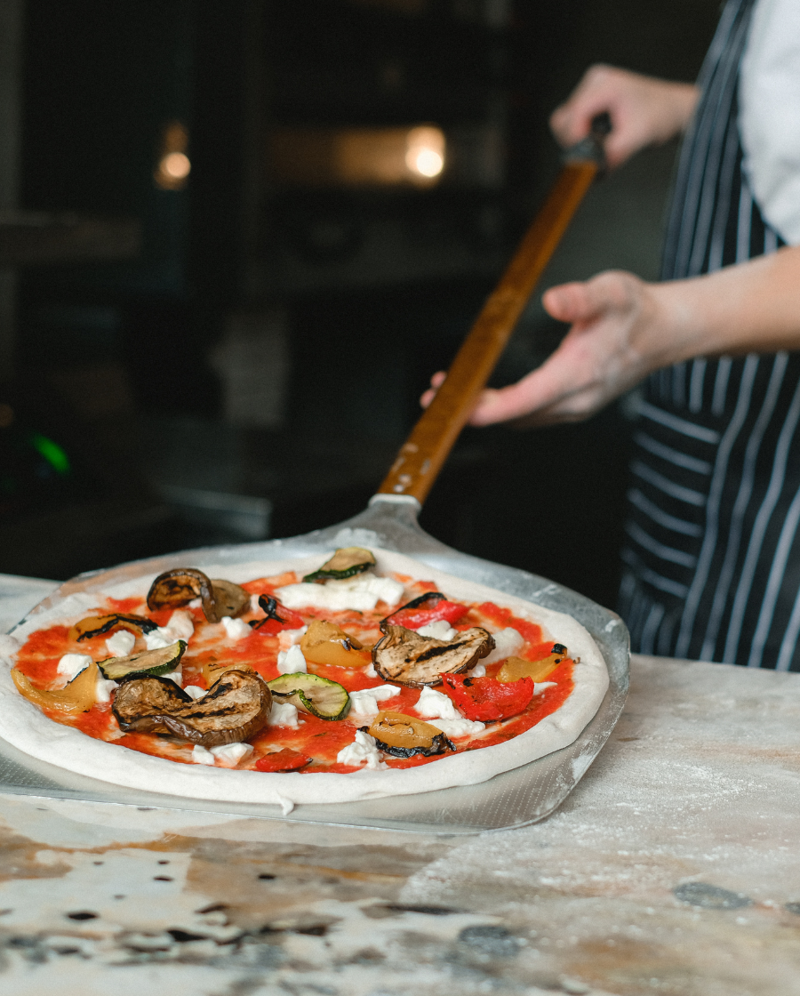 Pizzaiolo che impala la pizza Pizzaiolo che impala la pizza